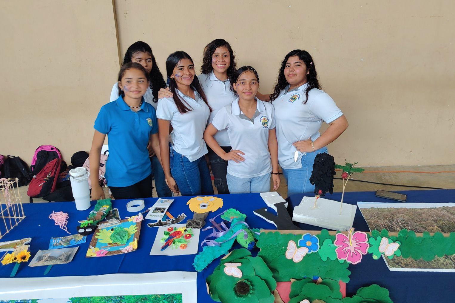 Group of students standing behind a table with handmade wildlife and habitat displays during Panama Wildlife Conservation’s Festival de las Guacamayas.